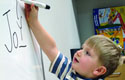 Child drawing on a white board.