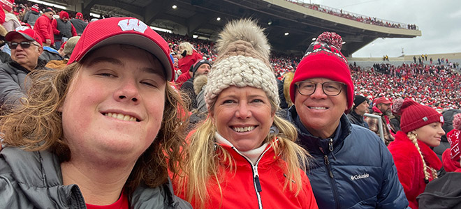 Whitney and Eric Bylin and their student at a Badger football game.