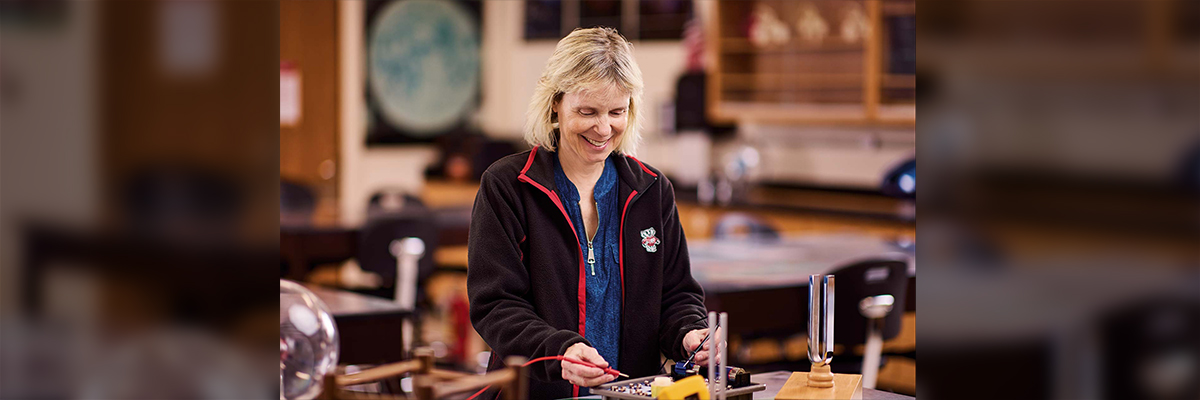Someone smiling and reviewing work they are doing on a table