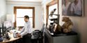 Nate Chin works at a computer in his home office, with keepsakes from his father nearby.