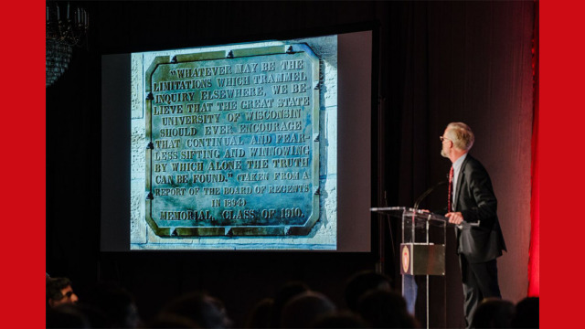 A presenter examining an image on a projected screen