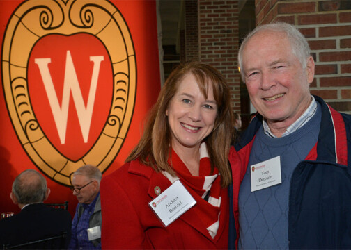 Two people posing by a Wisconsin banner
