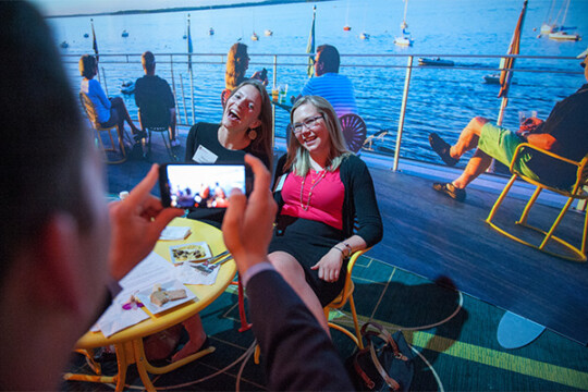 A pair of attendees posing in front of a mock Union Terrace for a photo