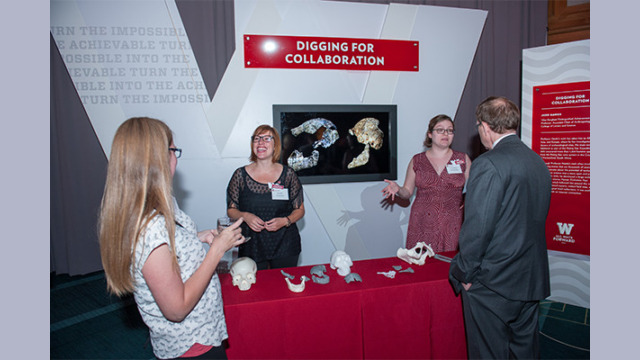 Attendees hearing about the "Digging for Collaboration" booth