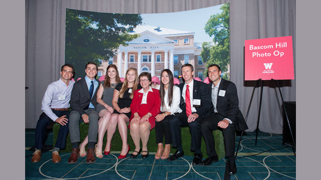Attendees posing for a photo in front of a mock Bascom Hill