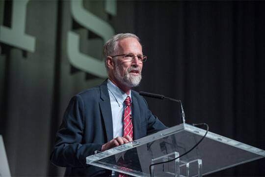 A person speaking in front of a crowd