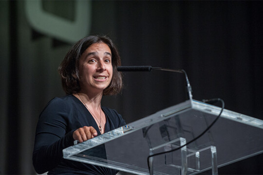 A person speaking in front of a crowd