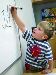 Child drawing on a whiteboard.