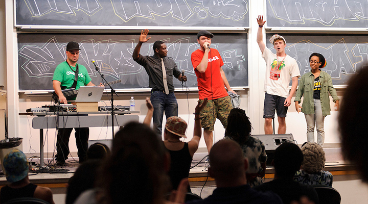 Educators and community leaders improvise on stage with hip-hop musicians during an evening performance at Van Vleck Hall.