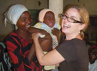 A woman handing a child to another person
