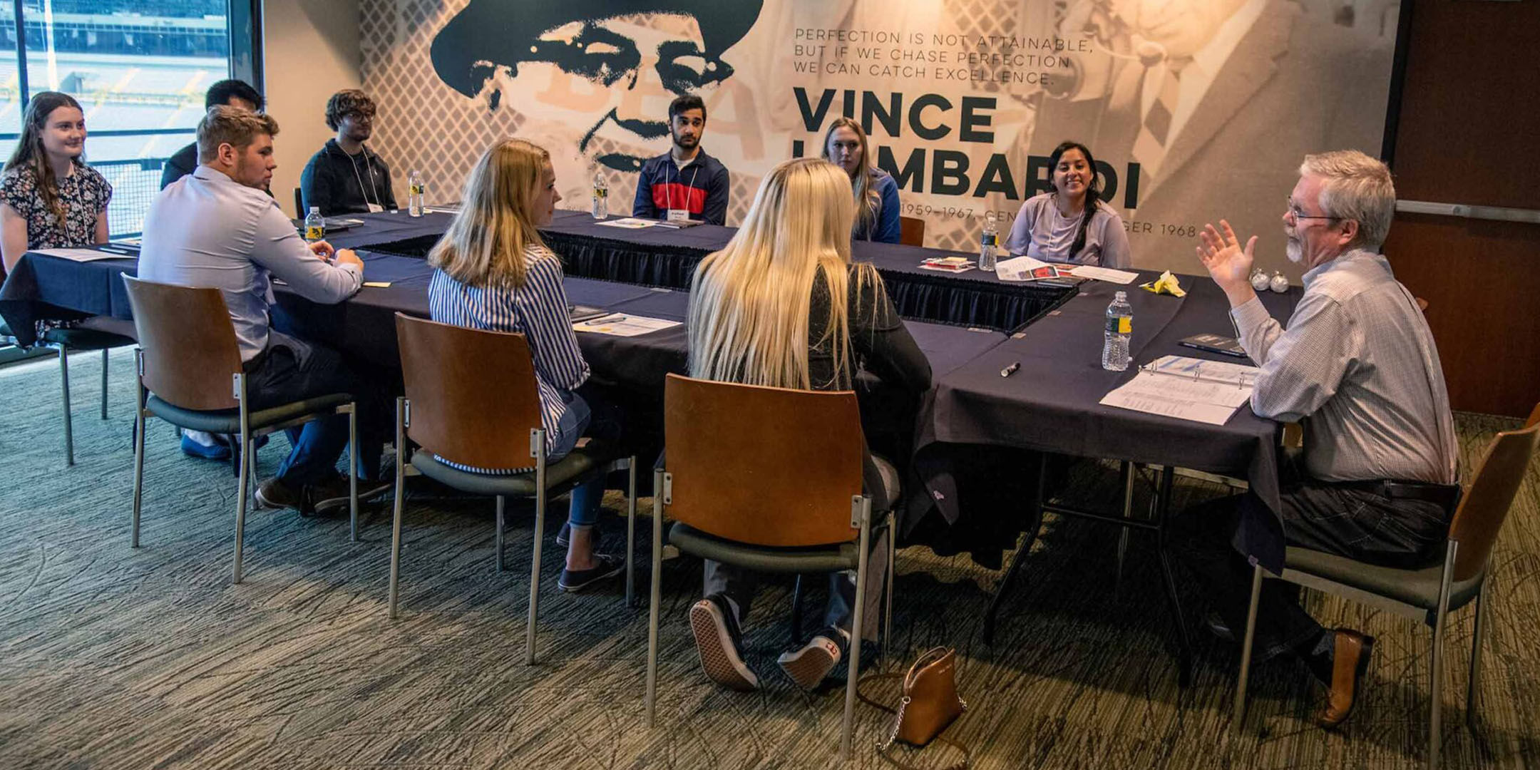 Students sit at a board table at the Leadership at Lambeau Summit.Photo by Paul L. Newby II