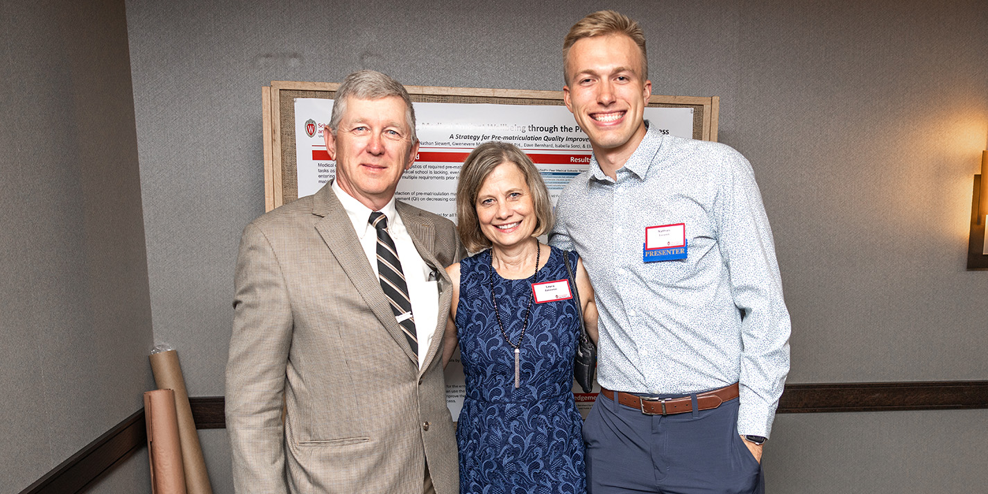 People pose for picture at a poster board presentation