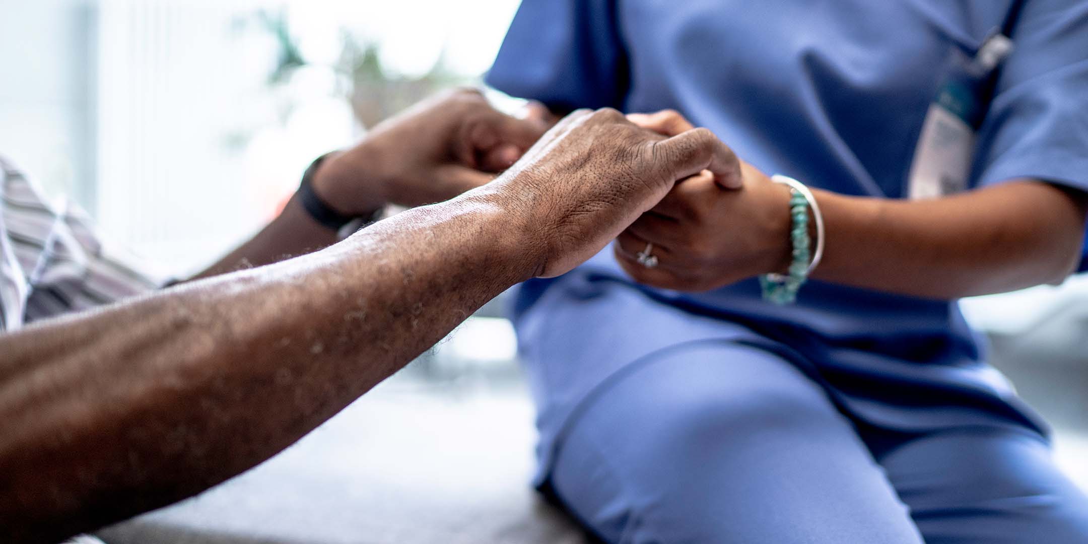 Nurse holding an elderly's hands