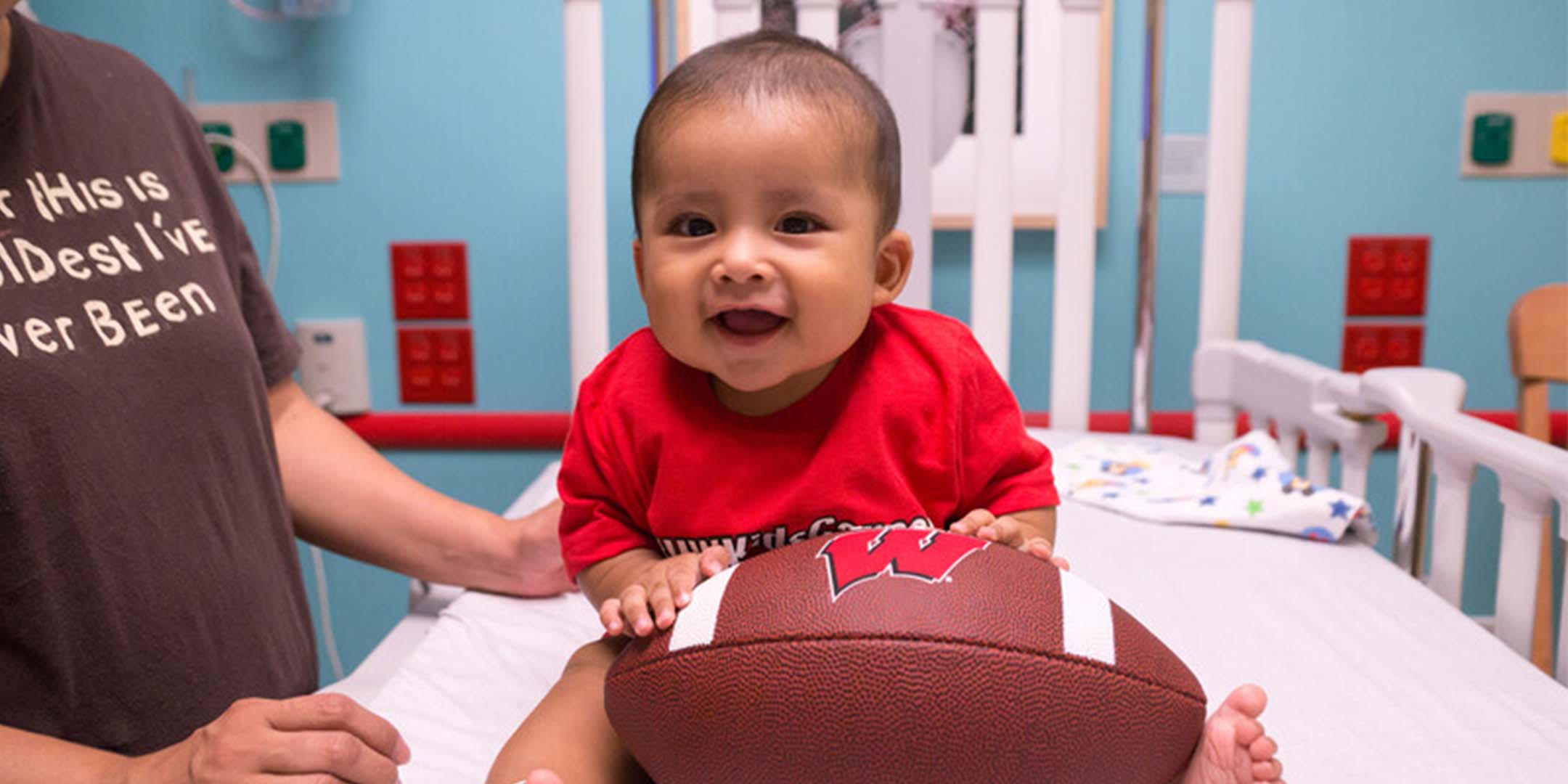 Baby holding a UW football