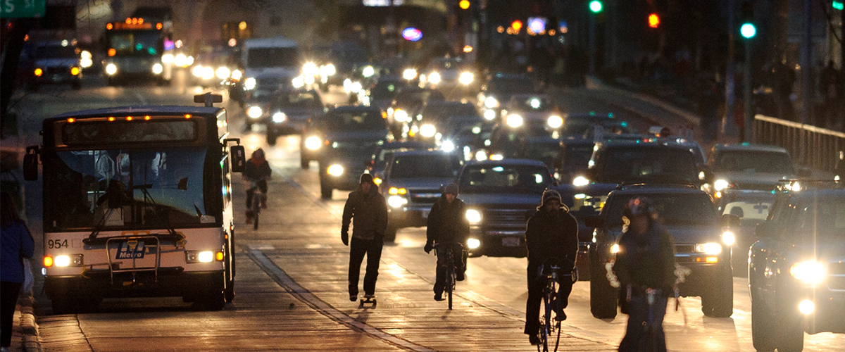 Traffic including a mix of cars, bicycles, and a bus